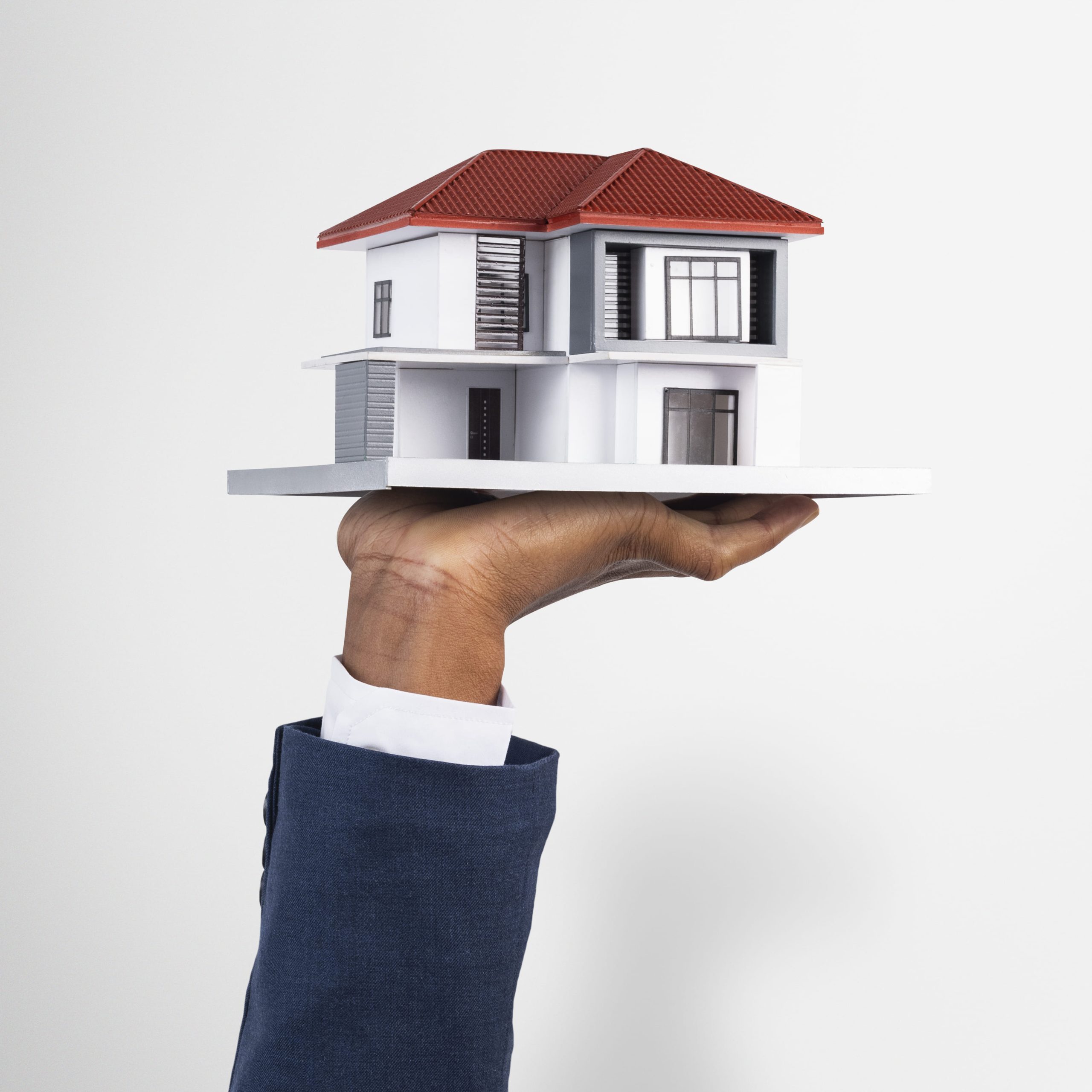 Hand holding a model of a family home