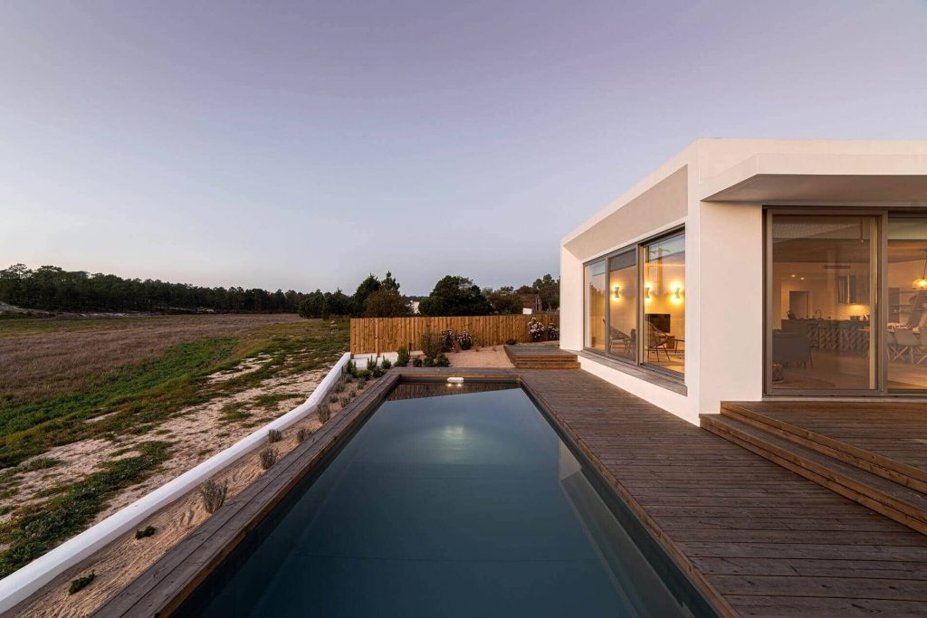 Desert Bloom Estate: Single-level modern estate with a long lap pool and deck at dusk in North Scottsdale, Scottsdale, AZ